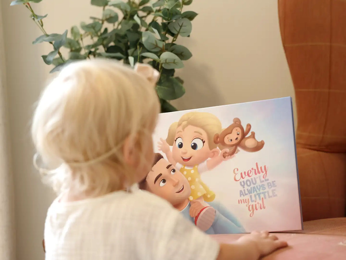 Girl looking at a book which is customized for her dad and her from Hooray Heroes.