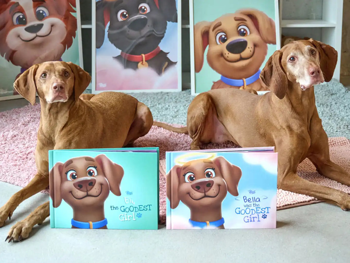 Two Vizsla dogs beside personalized dog books from Hooray Heroes featuring "Eli the Goodest Girl" and "Bella Was the Goodest Girl" custom covers which are also a great gift for pet lovers.