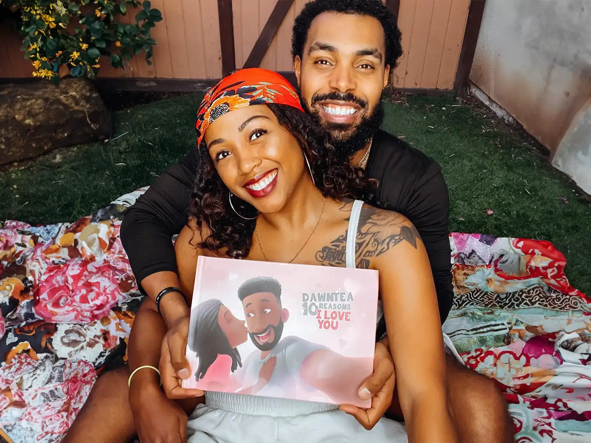 Loving couple cuddling while enjoying their romantic gift which is a personalized book with their names inside the book.