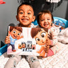 A brother and sister smile with their dream team adventure book for two or three friends, siblings or cousins.