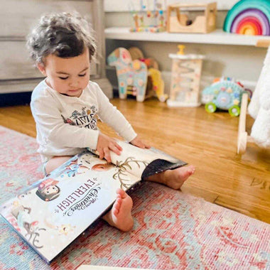 A toddles flips through her new custom Christmas story book, a beautifully festive Xmas present.