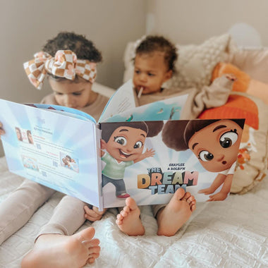 Two small children look at the pictures in their amazing treasure hunt book for siblings, friends, or cousins.