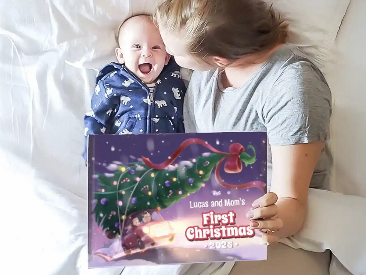 Mother and baby lying in bed holding a personalized Christmas book titled “Lucas and Mom’s First Christmas 2025.”