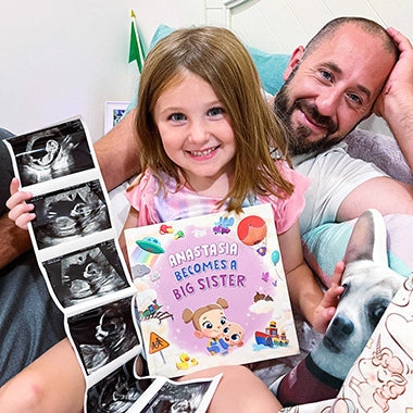 A little girl and her dad cuddling with a Hooray Heroes book